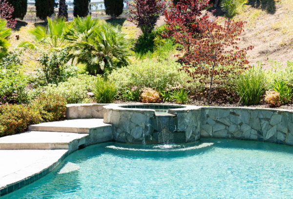 Taman tropis dengan kolam renang dan air terjun mini